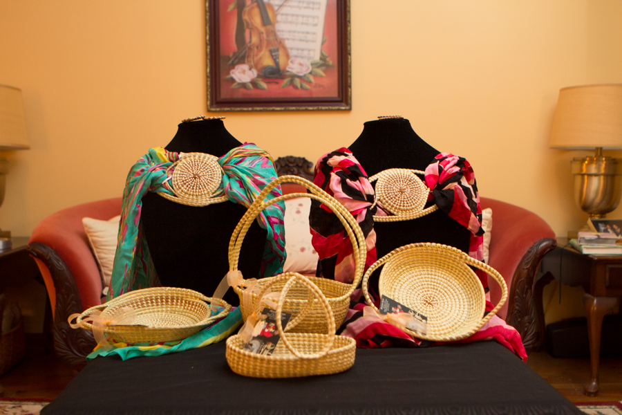 Sweetgrass baskets and pendants displayed with colorful scarves